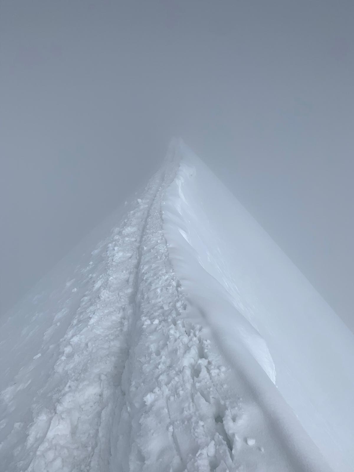 Smal snöås som försvinner upp i tät molnighet