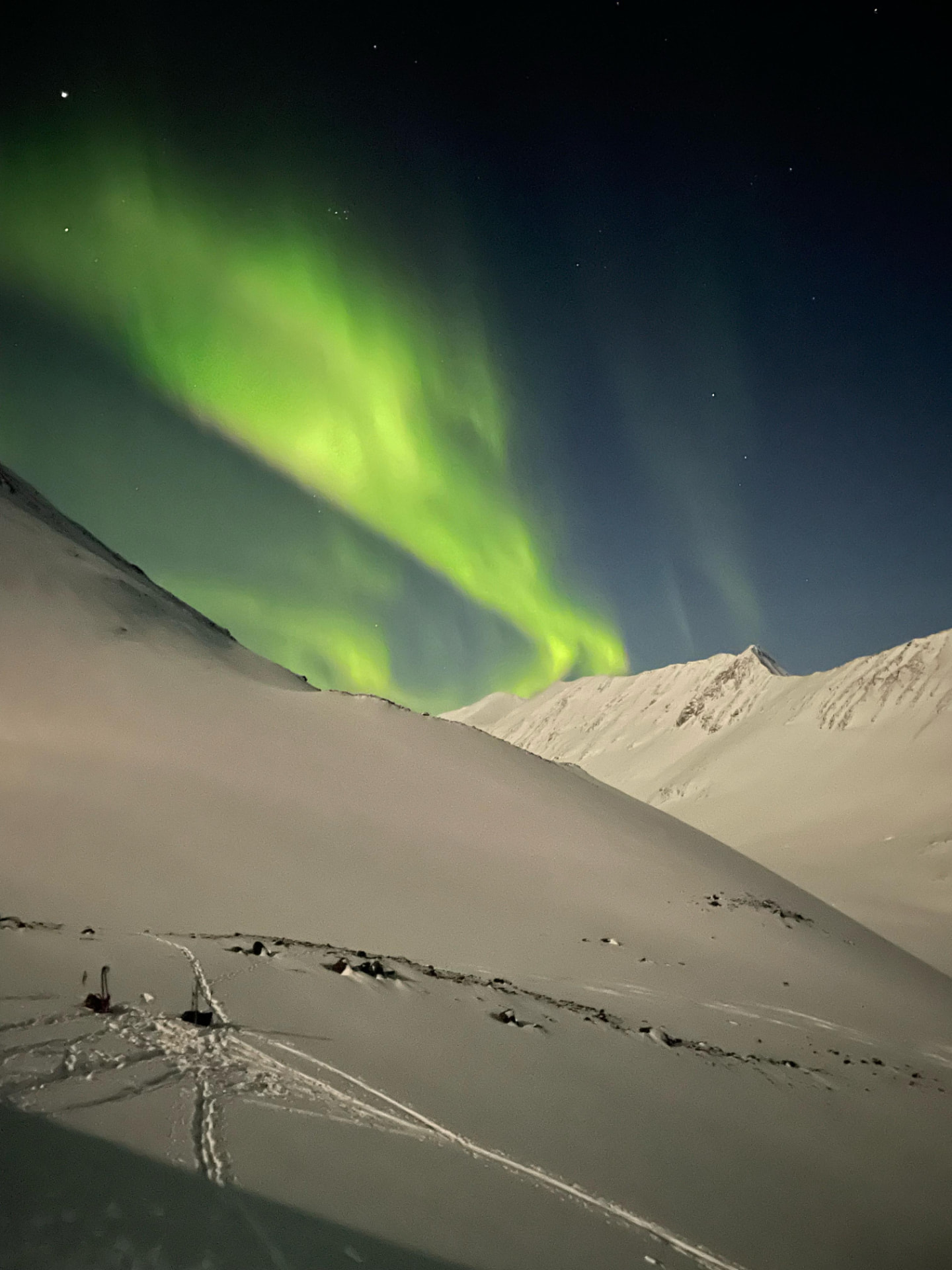 Norrsken över snötäckta fjällryggar i svenska Lappland